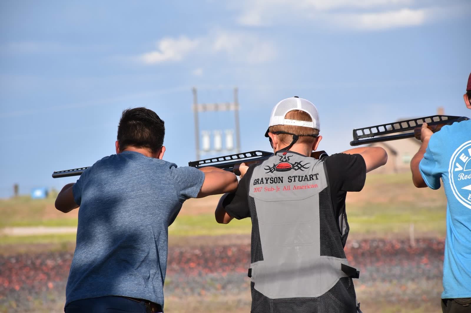 Three junior shooters from a sub-junior squad on the trap line.