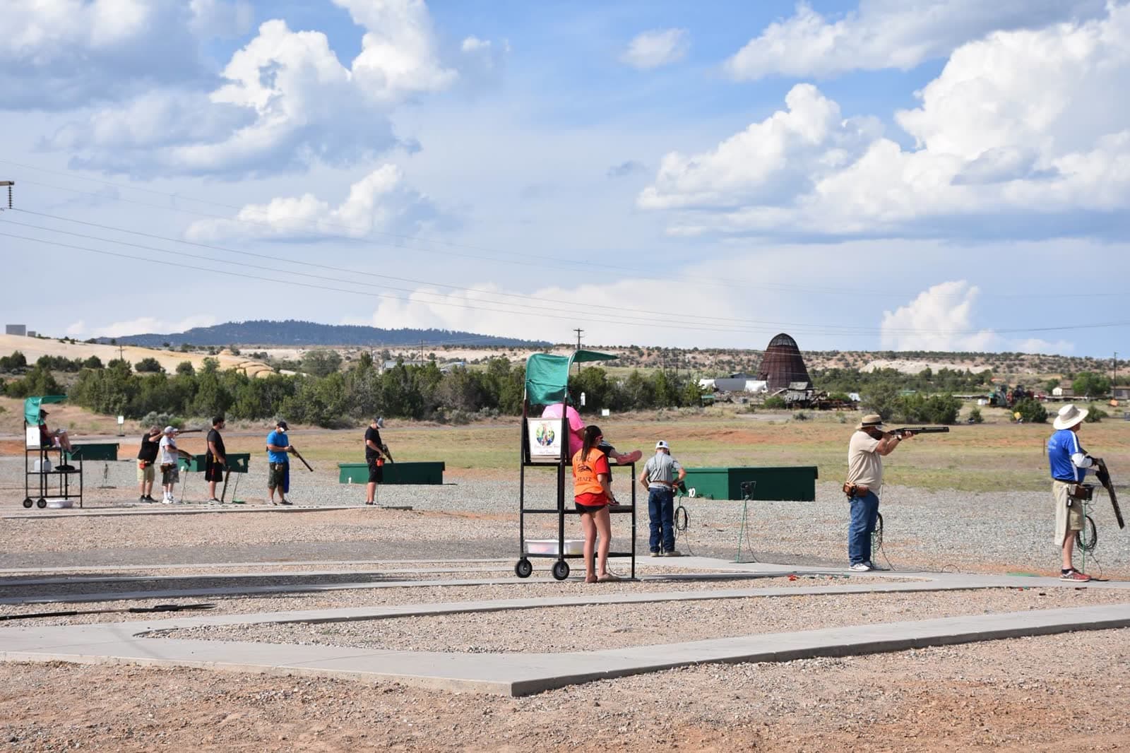 Shooters along the trap line with the iconic dome-shaped hill in the background.